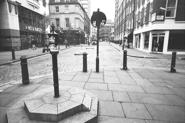 Hình 6: Trạm bơm (nước giếng) ở phố Broad vẫn còn được lưu giữ lại để kỷ niệm nỗ lực của bác sĩ Snow. Phía xa bên tay trái là quán rượu mang tên ông. Nguồn: http://www.twodimes.org/